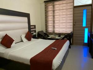 1 dormitorio con 1 cama y escritorio con sillas en Hotel Citi Heights, en Chandīgarh