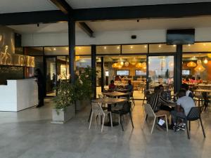 a group of people sitting at tables in a restaurant at Contemporary unit at the Blyde in Pretoria
