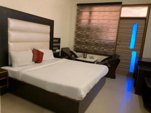 1 dormitorio con 1 cama grande con sábanas blancas en Hotel Citi Heights, en Chandīgarh