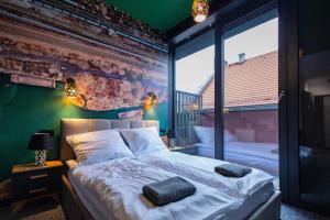 a bedroom with two beds and a green wall at Apartamenty Plebańska-Rynek in Gliwice