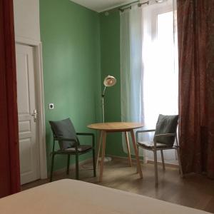 a room with a table and chairs and a lamp at MRTN APARTMENTS Studio & Suites - Aix-les-Bains, hypercentre in Aix-les-Bains +12 photos