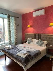 ローマにあるシニョール スイート コロッセオの赤い壁のベッドルーム1室(大型ベッド1台付)