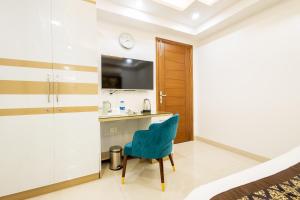 グルガオンにあるHotel Krish - Near Medanta and Fortis Hospital Gurugramのキッチン、青い椅子が備わる客室です。