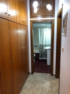 a hallway to a bathroom with a sink and a toilet at Viki’s Appartement near ktel Serron in Serres