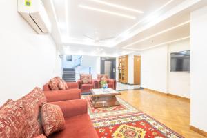 a living room with a couch and a table at Hotel Krish - Near Medanta and Fortis Hospital Gurugram in Gurgaon