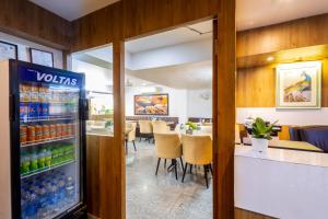 a restaurant with a refrigerator filled with drinks at Hotel Krish - Near Medanta and Fortis Hospital Gurugram in Gurgaon