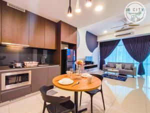 a kitchen and living room with a table and chairs at Grand Medini by RR JBcity in Nusajaya