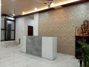 a lobby with a stone counter in front of a brick wall at 5 PETALS in Varanasi