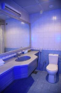 W łazience znajduje się toaleta oraz umywalka z lustrem. w obiekcie Roaa Al Andalus Hotel فندق رؤى الاندلس w Medynie