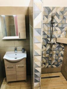 a bathroom with a sink and a shower at Tieffapartmanház Balatonszárszó in Balatonszárszó