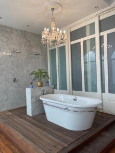 a bath tub in a bathroom with a chandelier at Cosy city stay in Cape Town
