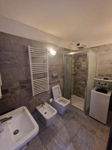 a bathroom with two sinks and a toilet and a shower at Mia Monza Suite in Monza