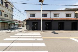 an empty street with a building and a crosswalk at Yagara Terrace House A in Osaka