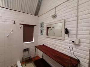 ein Badezimmer mit einem Spiegel und einer Holzbank in der Unterkunft Mukuku Rest Camp in Shimweghe + 37 Fotos