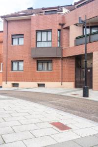an empty street in front of a brick building at Apartamentos GO - Arroyo San José in Arroyo de la Encomienda