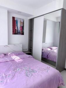 een slaapkamer met een roze bed en een spiegel bij 两室一厅两卫清迈市中心舒适大平层 in Chiang Mai