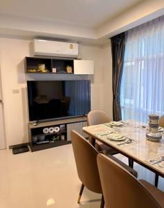 a dining room with a table and chairs and a television at 两室一厅两卫清迈市中心舒适大平层 in Chiang Mai