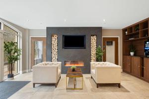 a living room with two chairs and a fireplace at Rock Mill Apartment 8 in Eyam