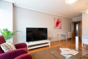 a living room with a large flat screen tv at Apartamentos GO - Arroyo San José in Arroyo de la Encomienda