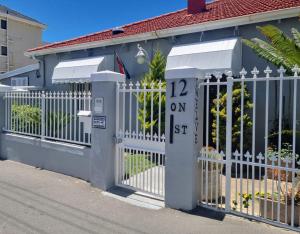 a white gate in front of a house at Twelveon1st in Cape Town
