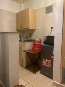 a small kitchen with a table and a refrigerator at COSY STUDIO APARTMENT CENTRALLY-LOCATED LOCATED IN SOUTH B WITH LIFTS AND FREE PARKING in Nairobi