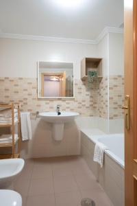 a bathroom with a sink and a tub and a toilet at Apartamentos GO - Arroyo San José in Arroyo de la Encomienda