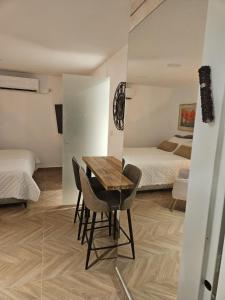 Zimmer mit einem Tisch und Stühlen sowie einem Schlafzimmer in der Unterkunft יחידת סאן סנטר באילת in Eilat
