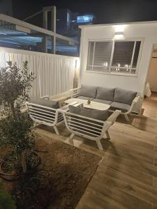 eine Terrasse mit einem Sofa, einem Tisch und Stühlen in der Unterkunft יחידת סאן סנטר באילת in Eilat