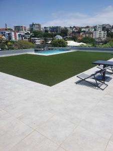 a picnic table on a patio with a grassy field at Trendy Apartment in Durban