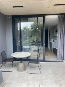 een tafel en stoelen in een kamer met glazen deuren bij Trendy Apartment in Durban