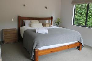 una camera con un grande letto con struttura in legno di Orchid Lane Bay of Island a Haruru
