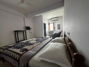 a bedroom with a bed and a chair in it at Dubai Hotel & Restaurant Kumarakom in Kumarakom