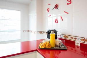 - un plateau de nourriture sur un comptoir rouge dans une cuisine dans l'établissement Apartamentos GO - Arroyo Ático Regato, à Arroyo de la Encomienda