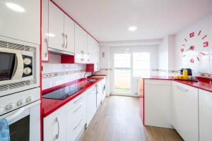 una cucina con armadi bianchi e ripiani rossi di Apartamentos GO - Arroyo Ático Regato A- 62 Salida 130 -Parking Gratuito ad Arroyo de la Encomienda