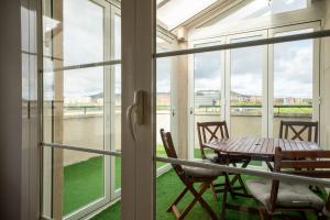 una stanza con un tavolo, sedie e finestre di Apartamentos GO - Arroyo Ático Regato A- 62 Salida 130 -Parking Gratuito ad Arroyo de la Encomienda Altre 9 foto