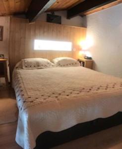 a bedroom with a large white bed with a window at VENTOUX 21 in Enchastrayes