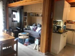 a living room with a couch and a kitchen at VENTOUX 21 in Enchastrayes