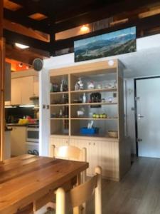 a dining room with a wooden table and a kitchen at VENTOUX 21 in Enchastrayes