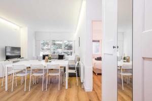 Saboredo by SeaMount Rentals في Naut Aran: غرفة طعام بيضاء مع طاولة بيضاء وكراسي