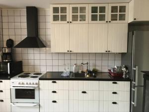 a kitchen with white cabinets and a sink at Gamla Badhuset in Borgvik