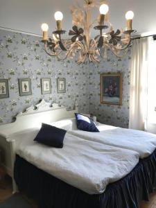 a bedroom with a large white bed with a chandelier at Gamla Badhuset in Borgvik