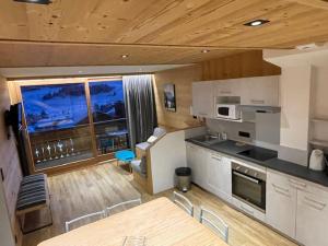a kitchen with a table and chairs in a room at Hotel Le Very in Les Saisies