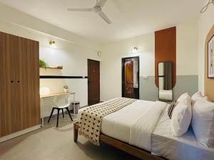 a bedroom with a bed and a desk in it at Olive Palace Road - by Embassy Group in Bangalore