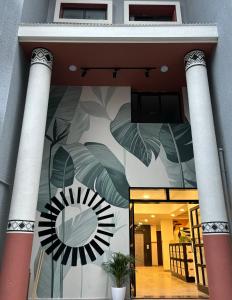 budynek z malowidłem słońca i liści w obiekcie Olive Palace Road - by Embassy Group w mieście Bengaluru