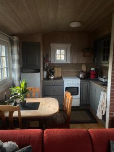 a small kitchen with a table and a stove at Cabin in the Mountain, Outstanding View & Solar Energy in Slidre