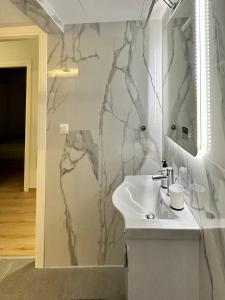 W łazience znajduje się umywalka i lustro. w obiekcie City Centre Apartment w mieście Patras
