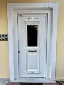 a white door with a sign on it at City Centre Apartment in Patra