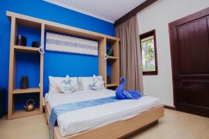 een slaapkamer met een bed met een blauwe muur bij Medana Bay Marina in Paloh