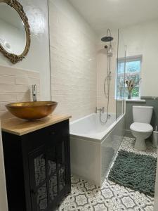 a bathroom with a tub and a sink and a toilet at 3 The Mews in Ryde