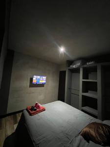 um quarto com uma cama e uma televisão na parede em Apartamento G4 em Guatemala